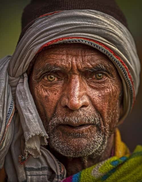 An elderly Indian man close up and looking rather sad